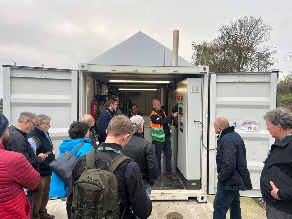 Group of people gathered around anaerobic digestion equipment